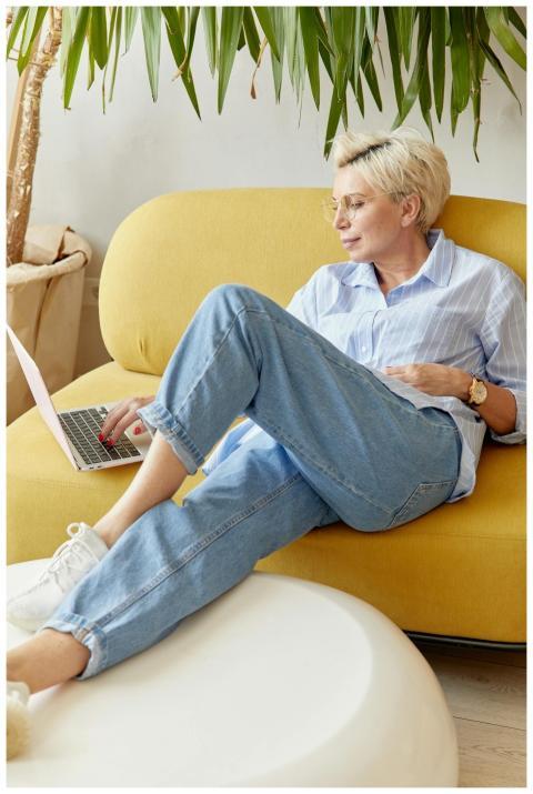Woman with short blonde hair using laptop while re