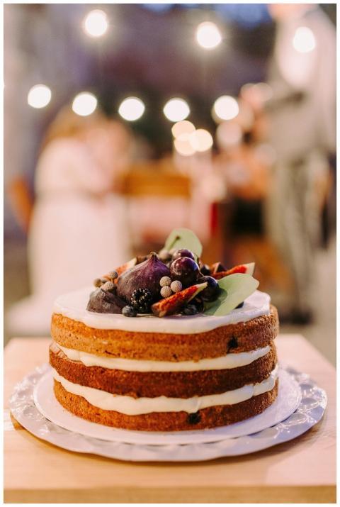 Naked-style cake topped with berries in an outdoor