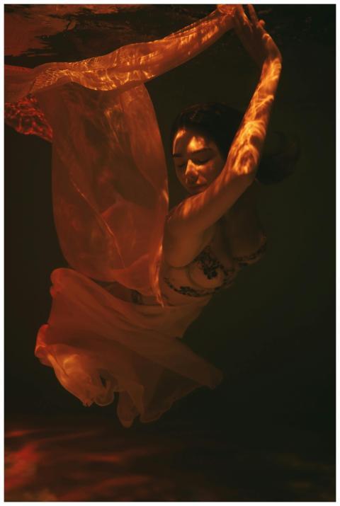 Capture of a woman elegantly dancing underwater wi