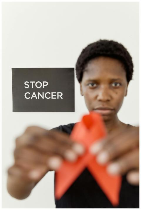 Portrait of a person holding a red ribbon promotin