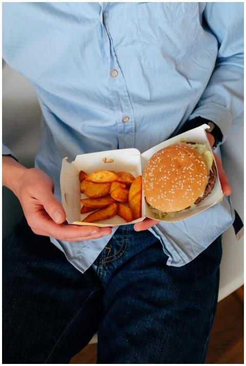 Man enjoying a tasty burger and potato wedges for