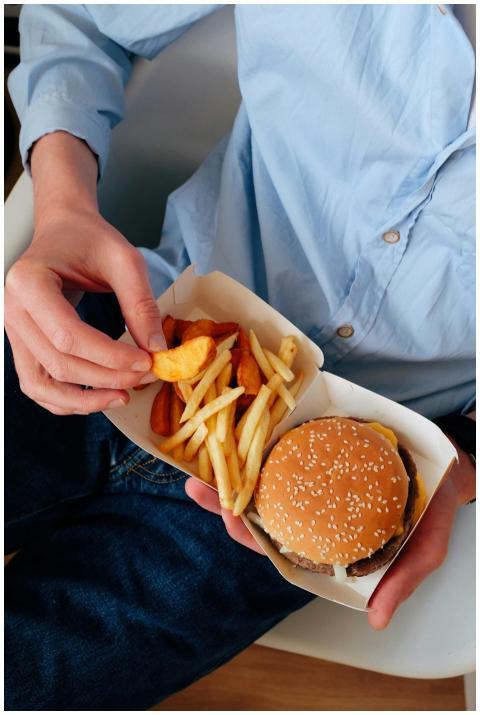 A person enjoys a classic burger and fries meal in