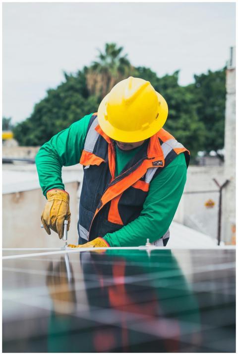 Professional solar panel technician working outdoo