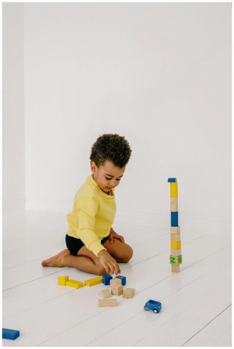 Young child playing with colorful wooden blocks on