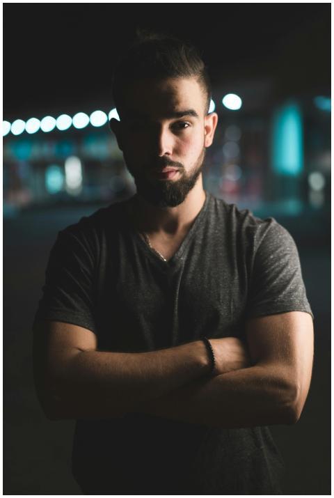 Moody portrait of a man standing with arms crossed