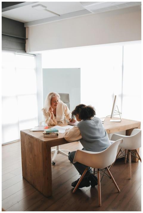 Two women engaged in a learning session at a woode