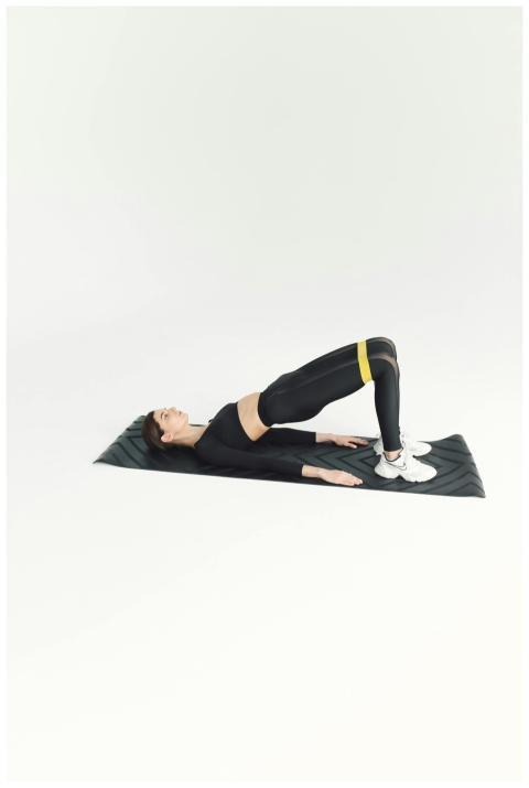Woman doing fitness workout on mat with resistance