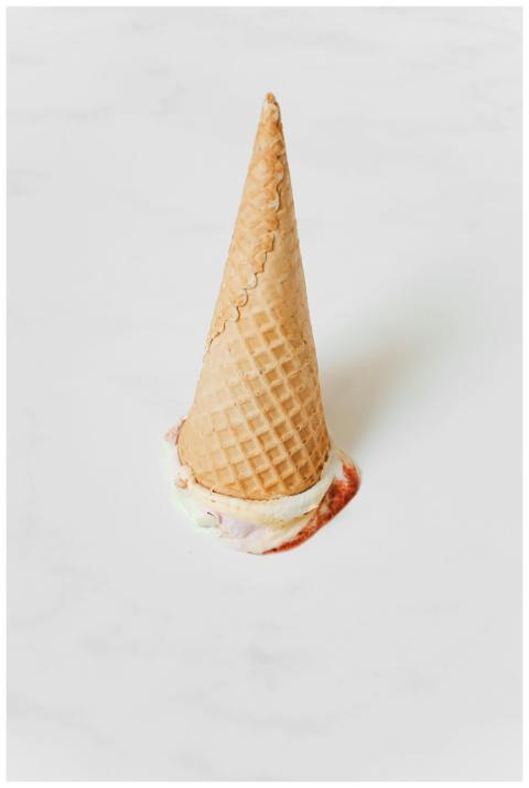Close-up of an upside-down ice cream cone on a whi
