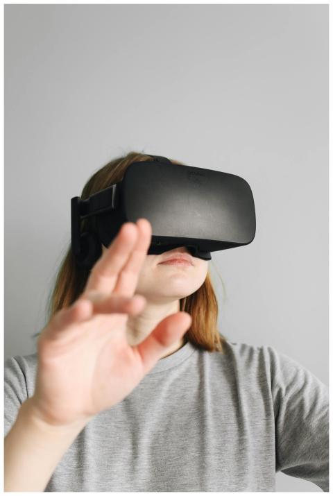 A woman in a gray shirt explores virtual reality w