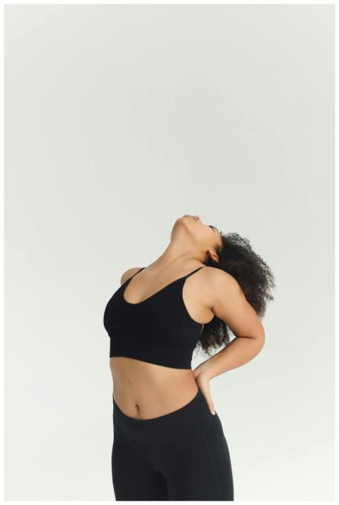 Woman stretching in black sportswear, emphasizing