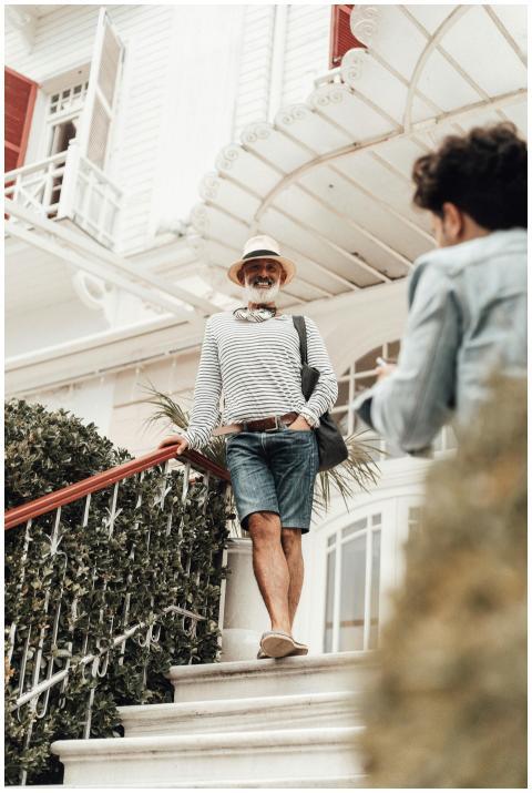 Full body smiling senior ethnic male in stylish su