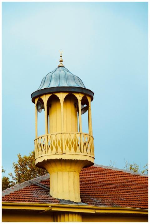 Photograph of a charming yellow tower with intrica