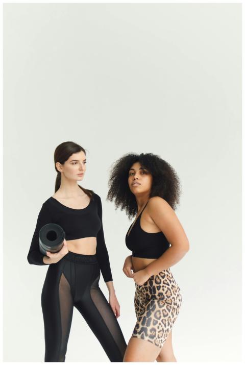 Two women in stylish activewear pose confidently i