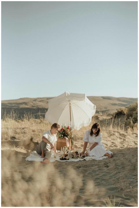 Young couple having romantic picnic sitting on whi