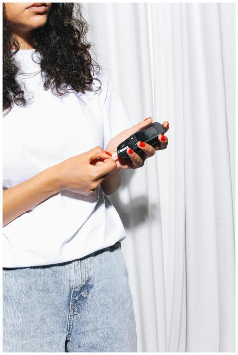A woman uses a glucometer to test her blood sugar