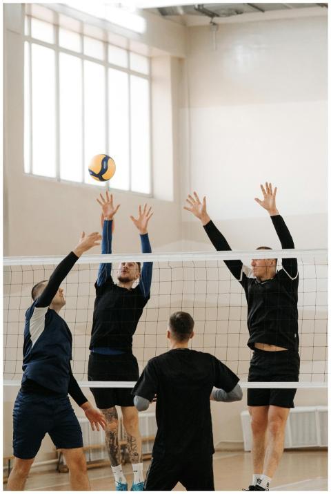Dynamic indoor volleyball match with athletes jump