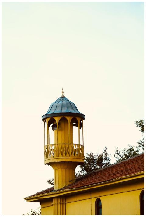 A yellow tower with a domed roof offers contrast a