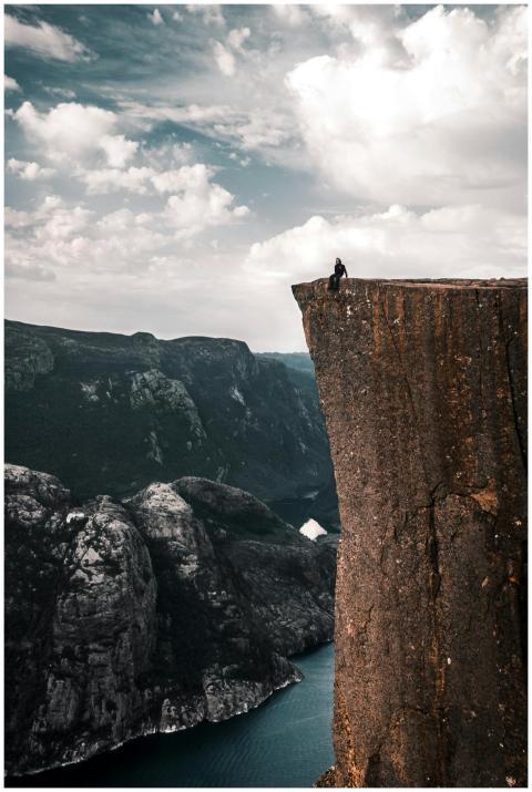 A daring traveler sits on the edge of Preikestolen