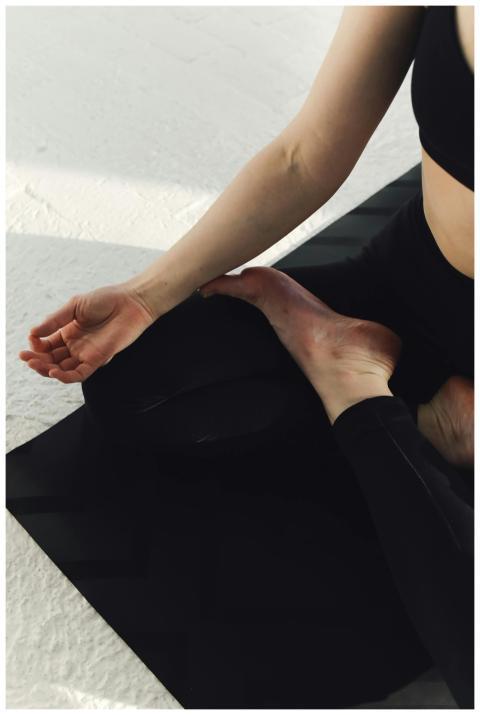 A woman practicing yoga meditation indoors on a ma