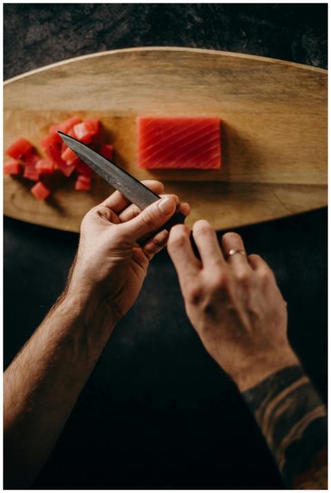 Chef expertly prepares tuna sashimi on wooden boar