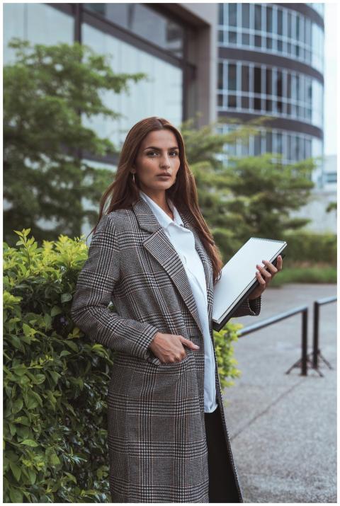 Confident woman in a stylish coat standing outside