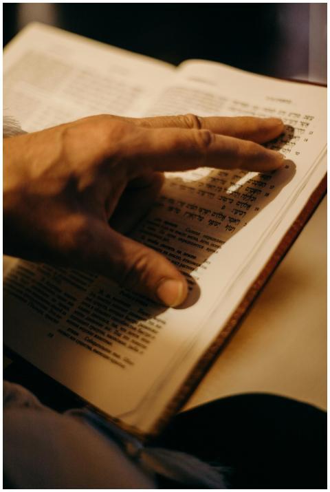 A hand gently touches the pages of an open book wi