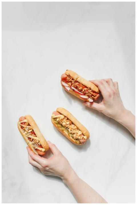 Overhead view of three gourmet hot dogs with toppi