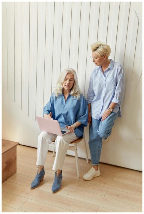 Two businesswomen discussing work on a laptop indo