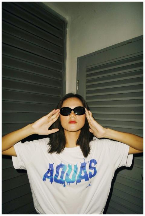 Young woman wearing sunglasses and a t-shirt, stri