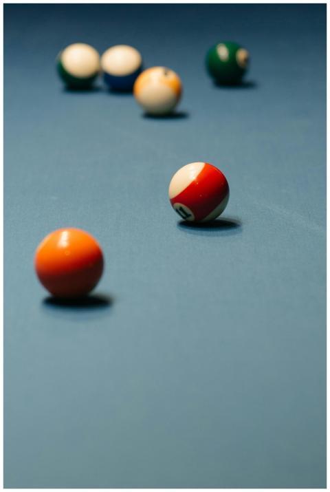 Several billiard balls on a pool table surface, fo
