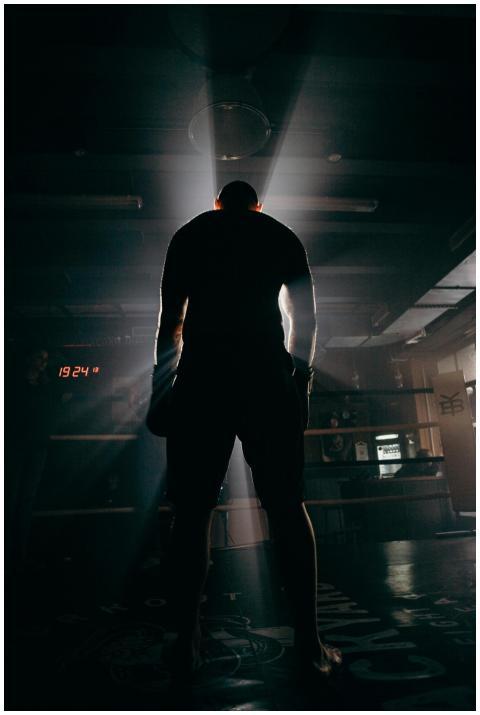 Silhouette of a boxer in a gym, illuminated by dra