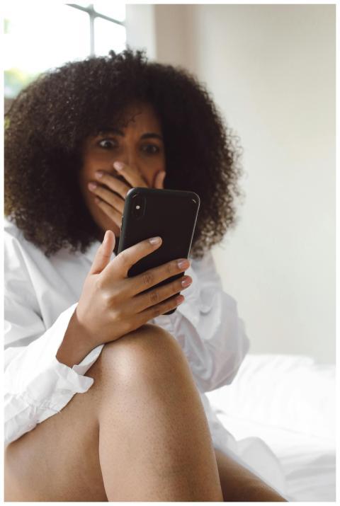 Black woman in white shirt, surprised expression,