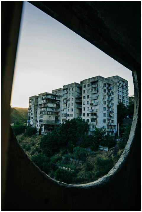 Soviet-style apartment buildings framed by ruins i