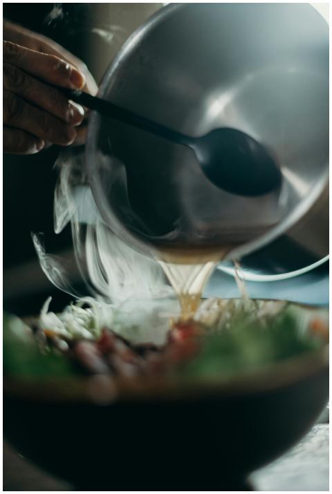 Close-up of steaming soup being poured into a bowl