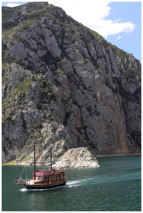 Wooden boat sails along tranquil waters with majes