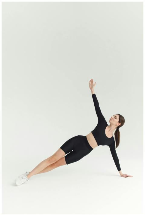 Fit woman in activewear doing a side plank on a wh