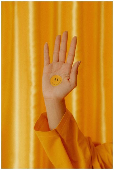 A hand featuring a smiley sticker stands out again