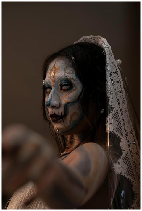 Woman in lace veil with intricate Halloween face p