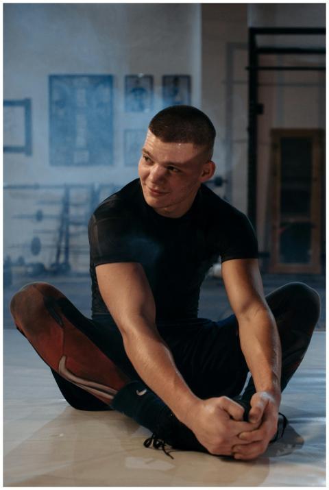 Focused athlete stretching indoors at gym, prepari