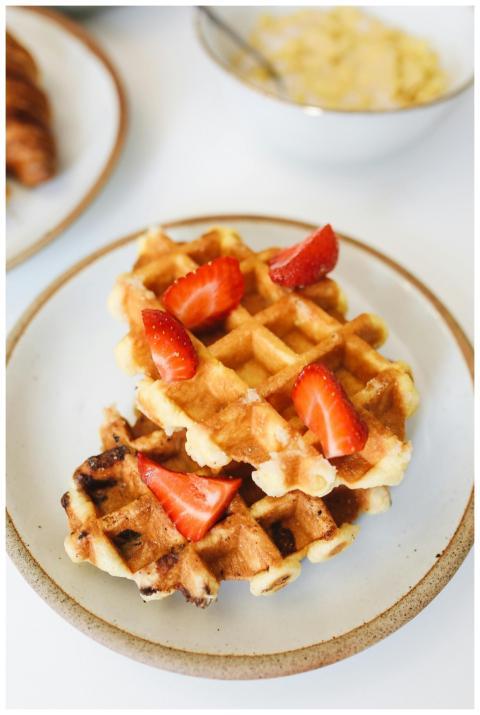 Golden waffles topped with fresh strawberries on a