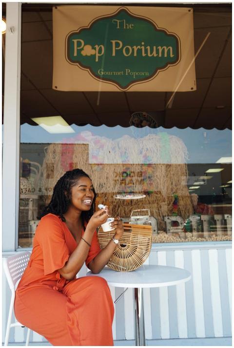 A smiling woman enjoys ice cream while sitting out