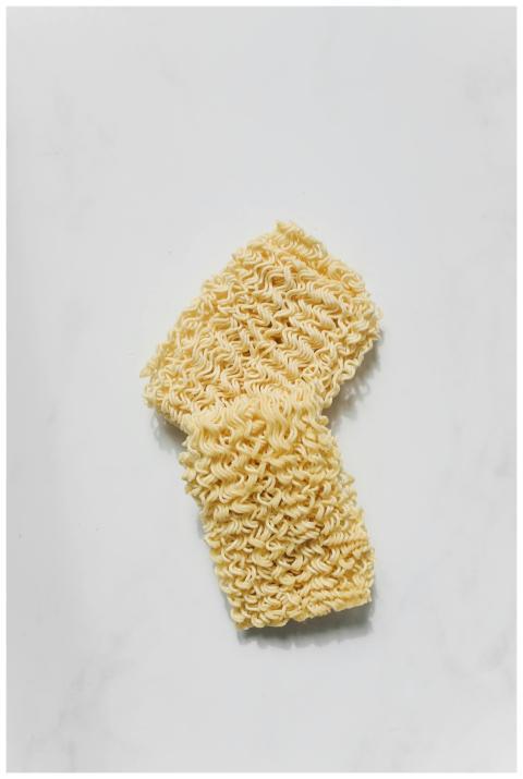 Close-up of uncooked instant noodles on a white ba