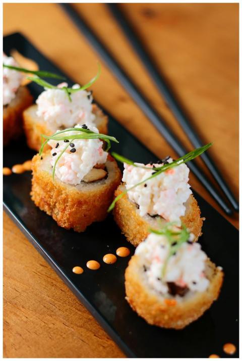 Close-up of crispy sushi rolls topped with crab sa