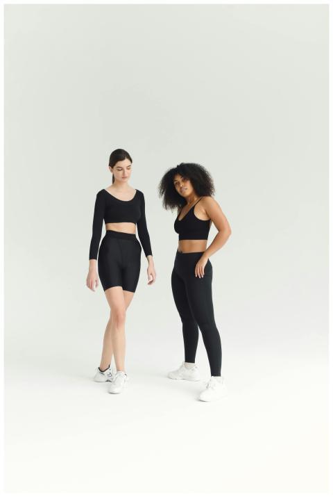 Two women in stylish activewear pose confidently i
