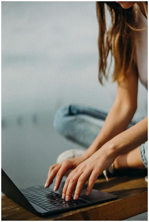 A young woman working remotely on her laptop by a
