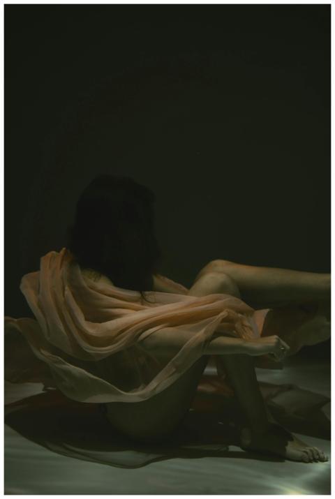 Moody underwater portrait of a woman wrapped in fl