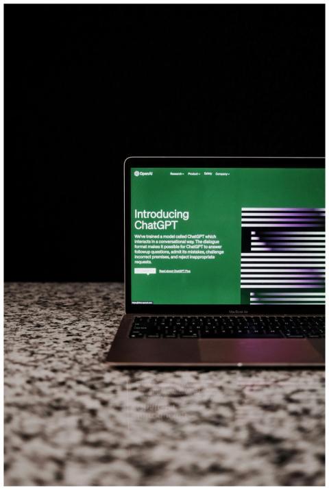 Laptop showing ChatGPT interface on a marble surfa