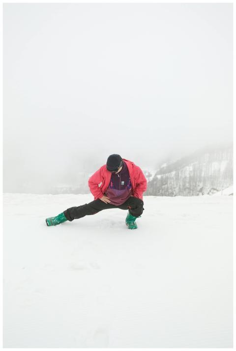 Person stretching in a snowy winter landscape, wea