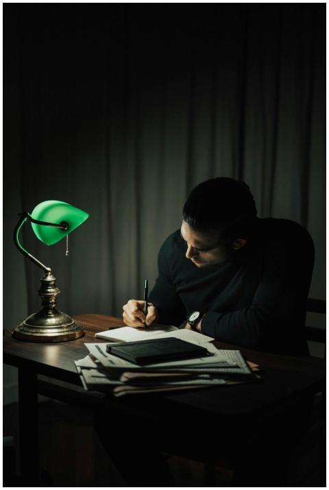 Concentrated male taking notes in notepad while si