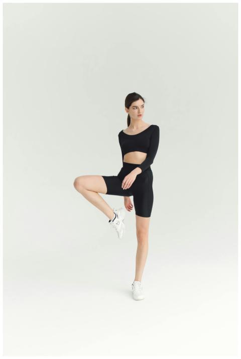 Beautiful woman in activewear balancing in a studi